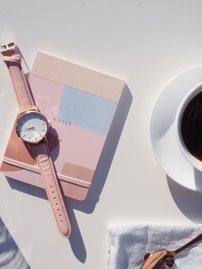 Round Gold-colored Analog Watch With Pink Leather Strap on Pink Notebook